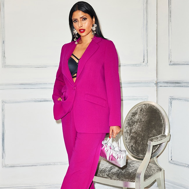 The model wears a magenta coloured suit