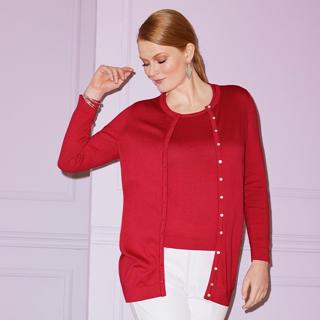 The model wears a red cardigan