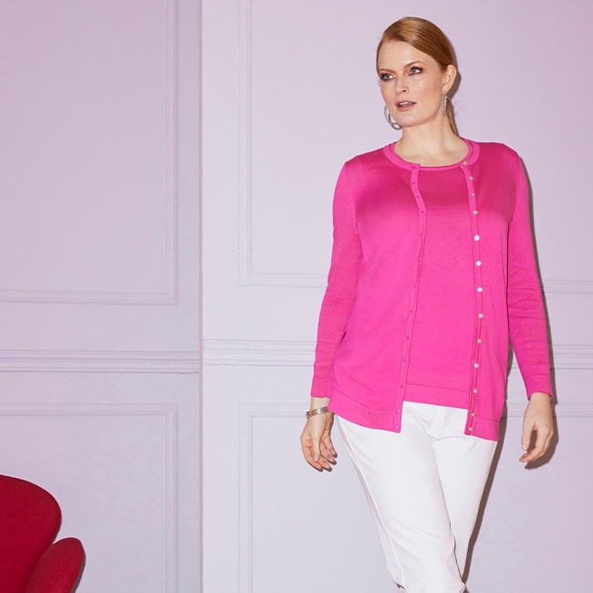 The model wears a pink cardigan