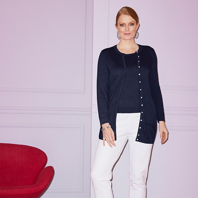 The model wears a blue cardigan
