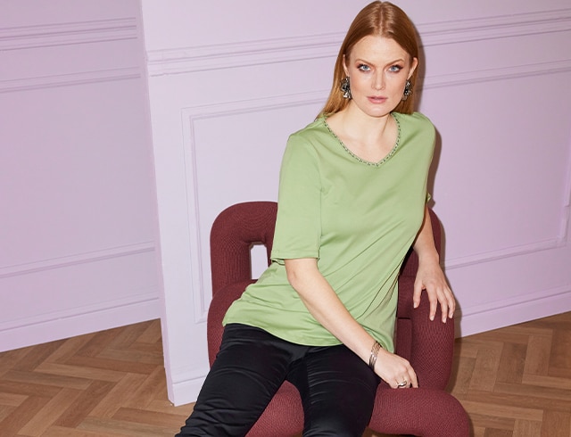 The model wears a green shirt made of Pima Cotton