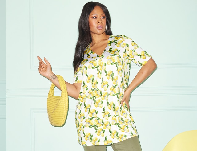 The model is wearing a slinky shirt with lemon print