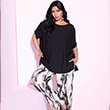 The model wears a black t-shirt and patterned pants