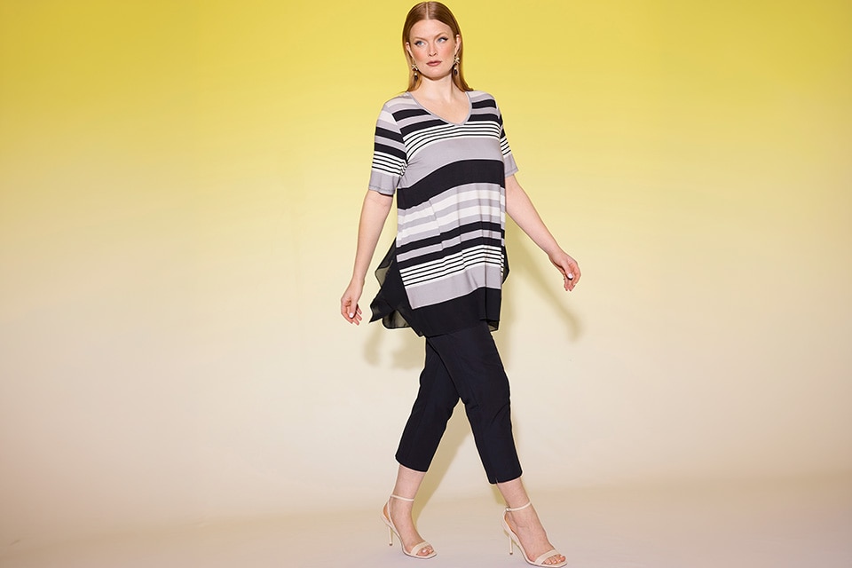 The model wears a striped shirt and black pants.