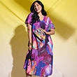 The model is wearing a colorful floral dress