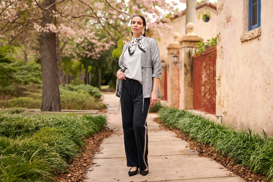 The model wears a striped shirt and black pants.