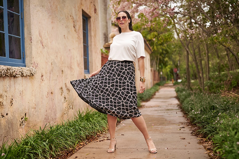 The model wears white pants and a leopard printed t-shirt.