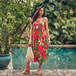 The model is wearing a colorful floral dress
