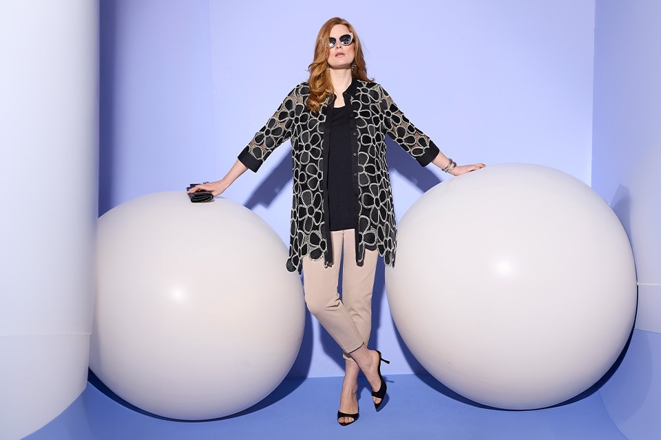 The model wears a black cardigan.