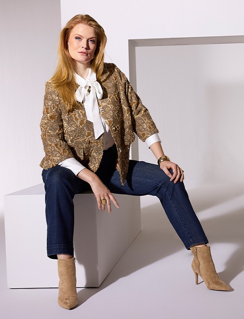 The model is wearing a brown blazer and a brown pants.
