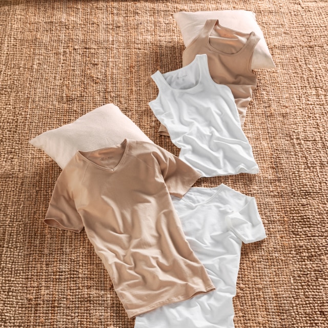 A men is wearing a nude-colored t-shirt and a white shirt
