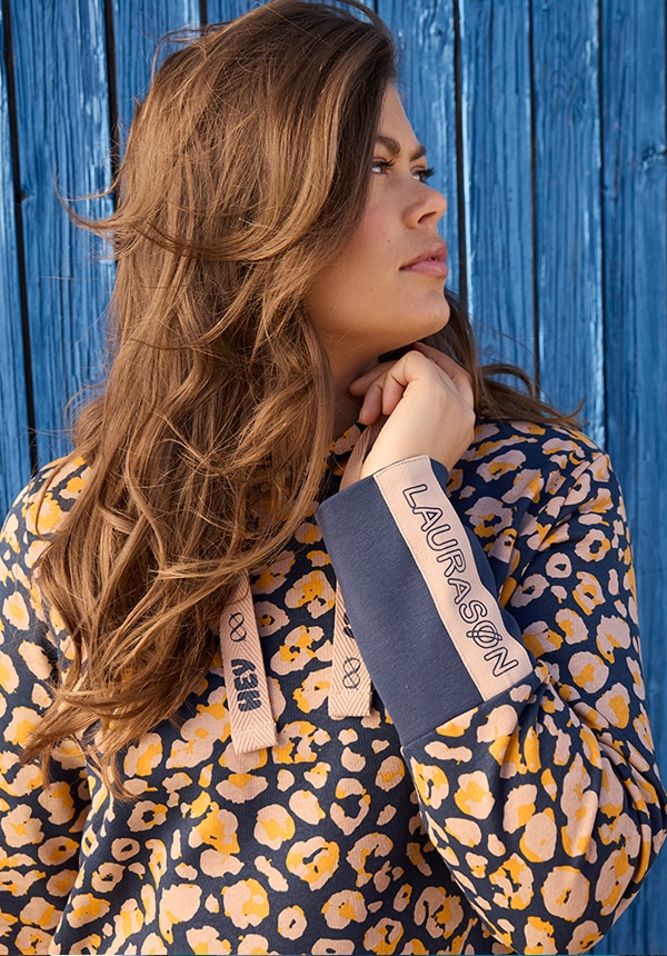 Model posiert mit einem blauen Kleid und steht im Wasser