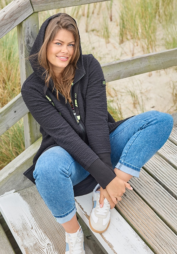 Model posiert mit einem blauen Kleid und steht im Wasser