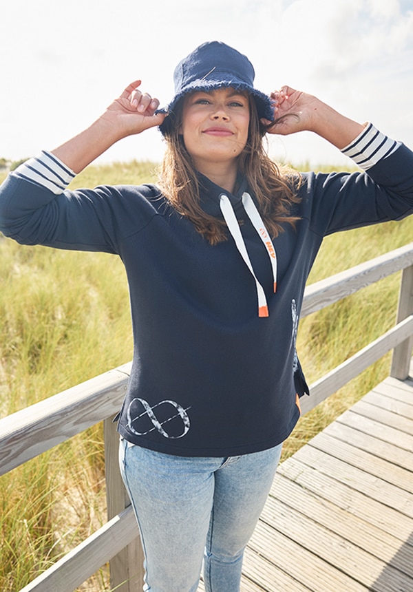 Model posiert mit einem blauen Kleid und steht im Wasser