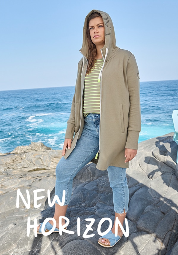 Model posiert mit einem blauen Kleid und steht im Wasser