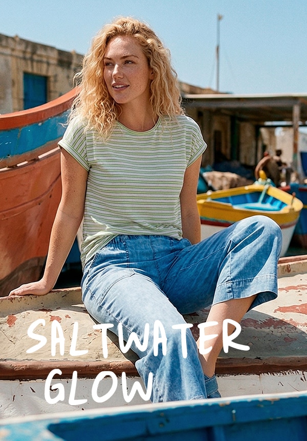 Model trägt ein grün gestreiftes Shirt und eine Jeans.
