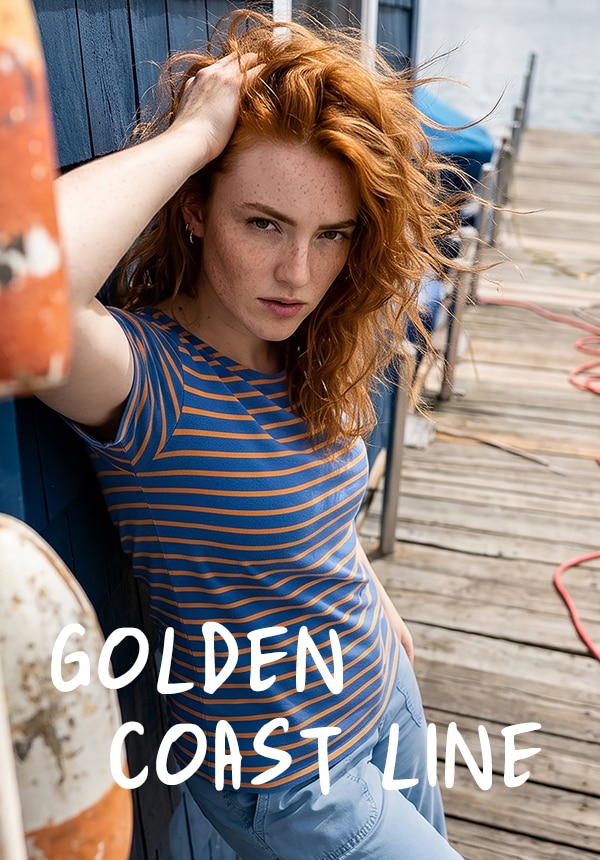 Model trägt ein grün gestreiftes Shirt und eine Jeans.