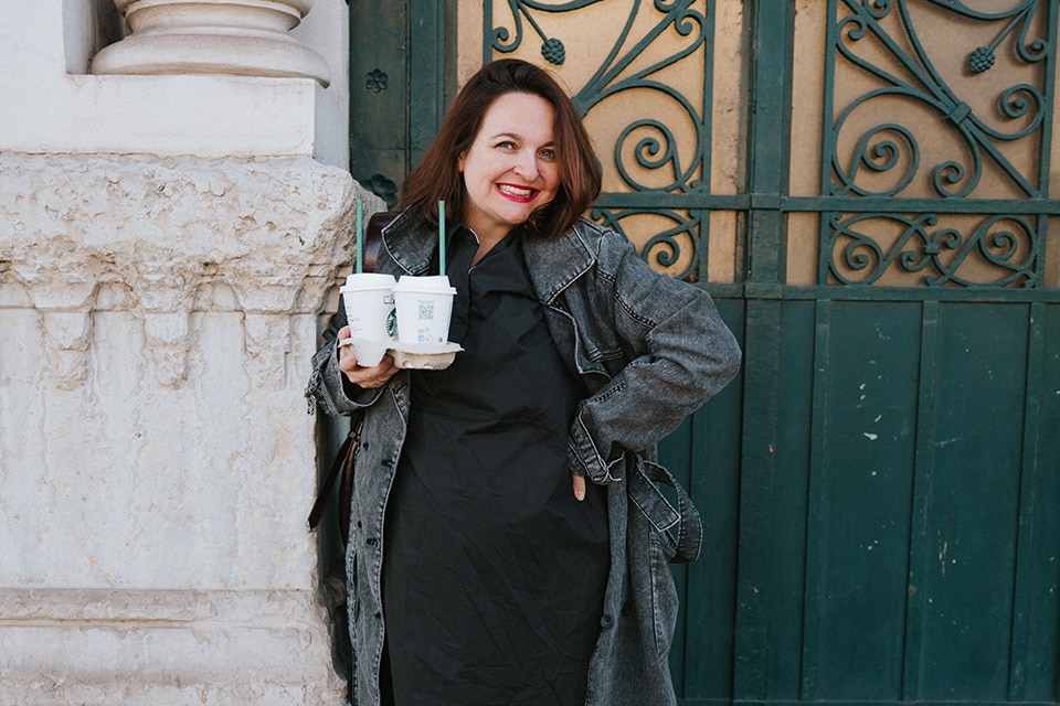 The model wears a black dress with a grey jeans jacket