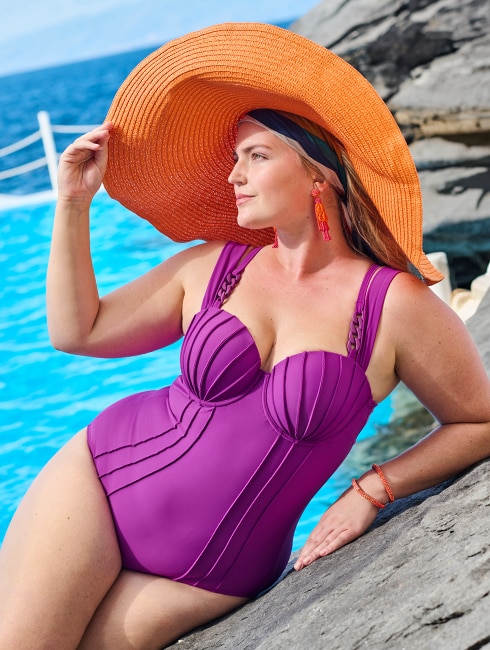 The model wears a figure-hugging swimming costume
