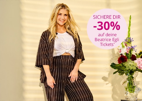 Beatrice Egli trägt ein braunes Set mit weißen Streifen.
