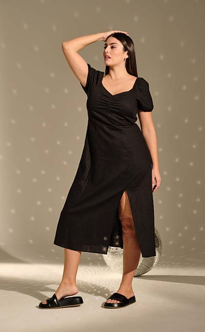 The model poses in a black dress
