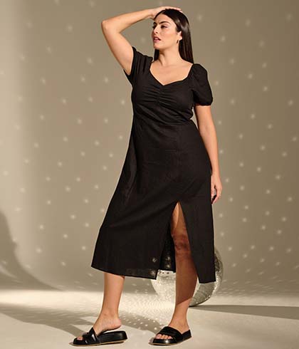 The model poses in a black dress