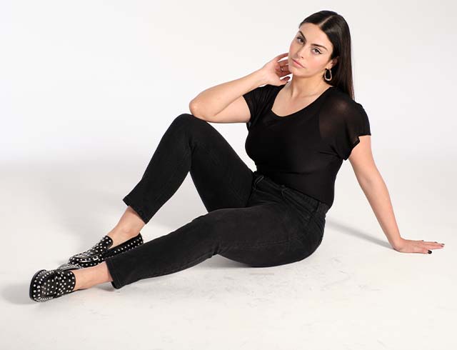 Model poses on the ground in a black linen mix t-shirt

