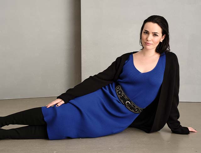 The model is wearing a wide black long skirt