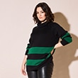 The model is wearing a black sweater with green stripes