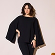 The model is wearing a black blouse with wide, flared sleeves