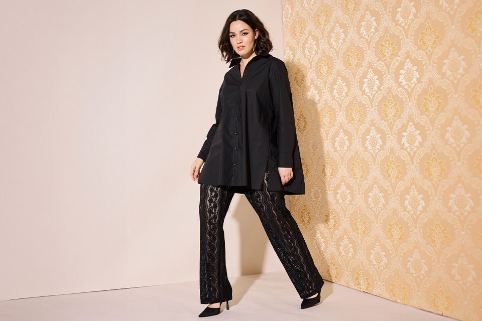 The model is wearing lace pants and a black blouse