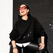 The model is wearing a black sweater