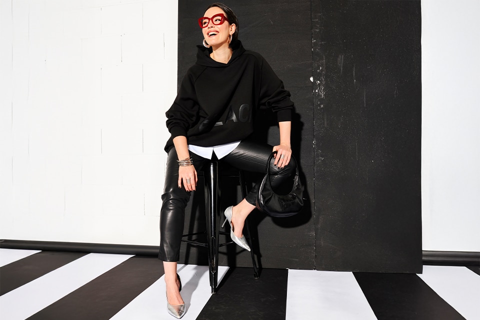 The model wears a black swaetshirt and trousers