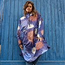 The model poses in a colorful rain cape 
