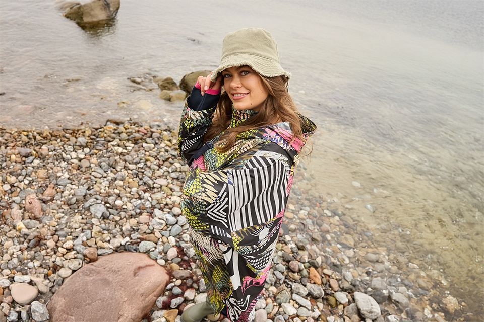 The model wears a colorful raincape