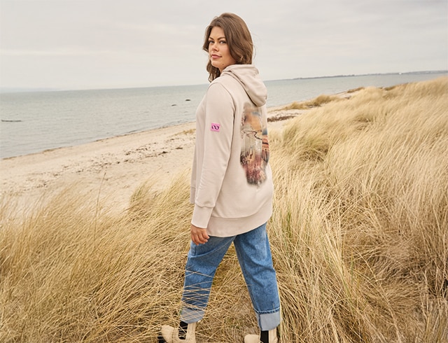 The model wears a beige sweatshirt