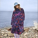 The model poses in a colorful rain cape 
