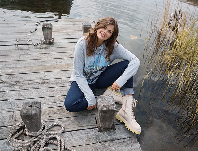 The model wears a beige sweatshirt