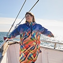 The model poses in a colorful rain cape 
