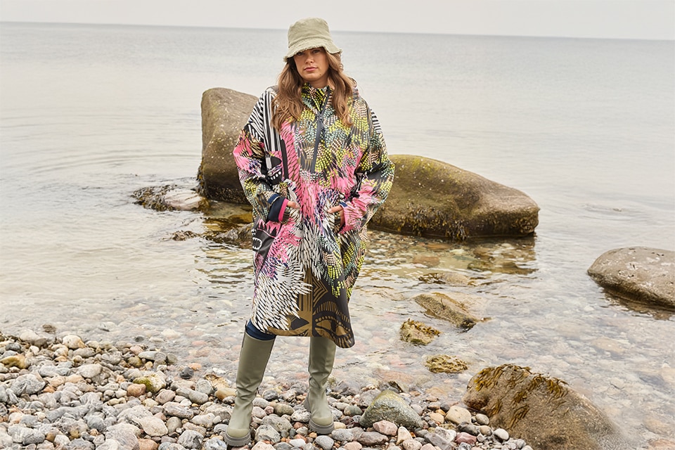 The model wears a colorful raincape