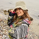 The model poses in a colorful rain cape 
