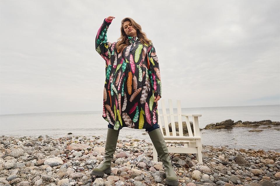 The model wears a colorful raincape