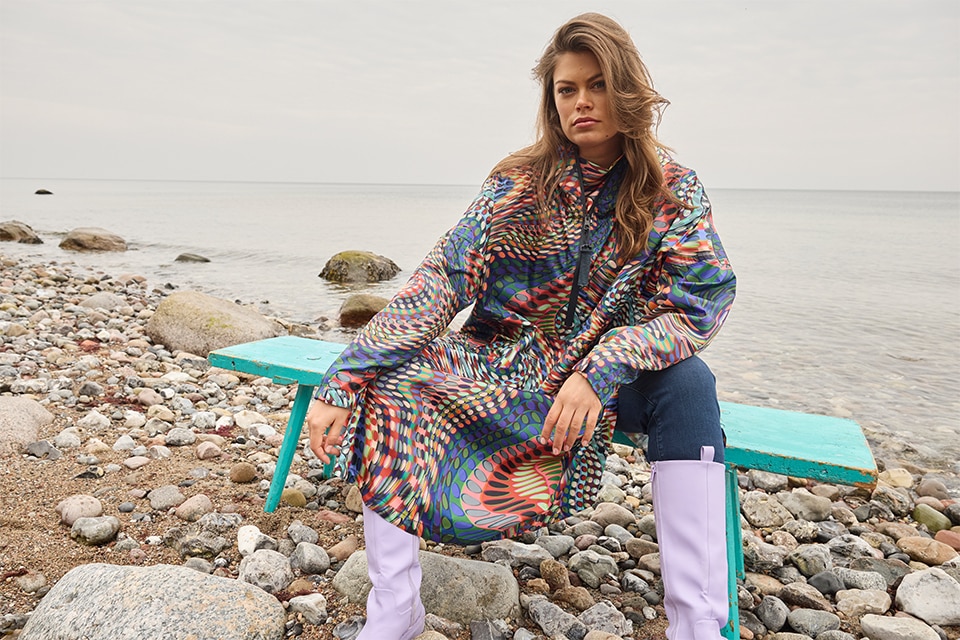 The model wears a colorful raincape
