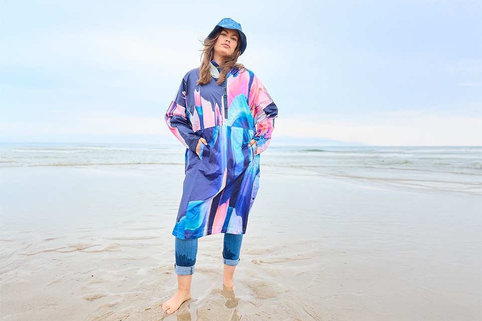 The model wears a colorful raincape