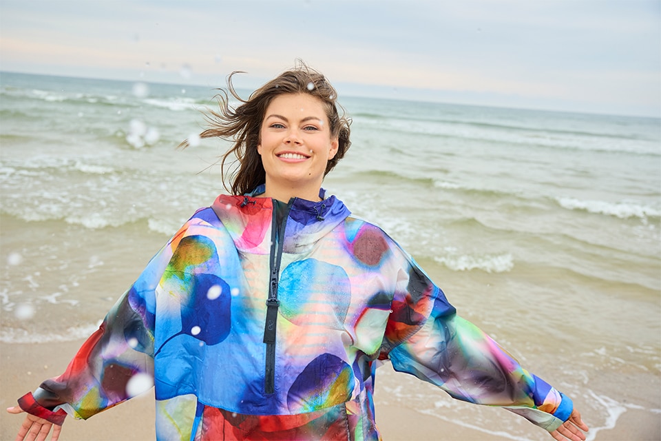 The model wears a colorful raincape