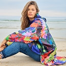 The model poses in a colorful rain cape 
