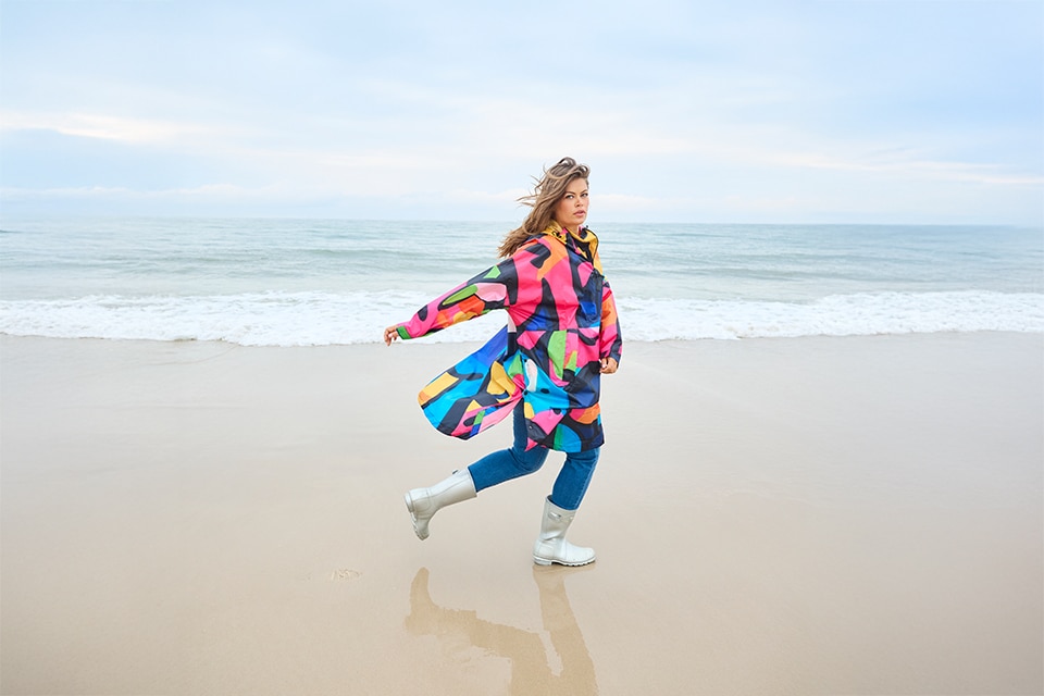 The model wears a colorful raincape