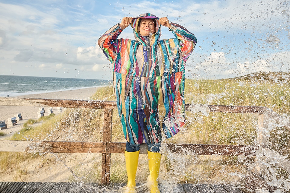 The model wears a colorful raincape
