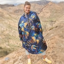 The model poses in a colorful rain cape 
