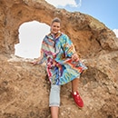 The model poses in a colorful rain cape 

